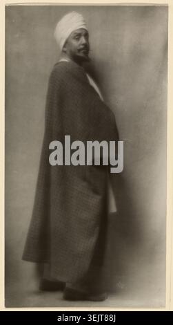 Otis Skinner (in Kismet), 1912. Zusätzliche Informationen: Porträt von Otis Skinner in voller Länge mit Spitzbart, erhöhter Augenbraue und weißem Turban, der über seine rechte Schulter auf den Betrachter blickt und lose, formlose Kleidungsstücke trägt. Stockfoto