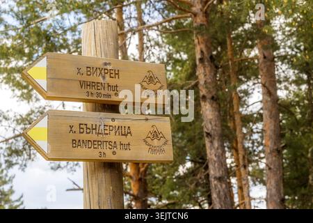 Bansko, Bulgarien - 27. Mai 2026: Hölzerner Wegweiser im Pirin-Nationalpark mit Wegbeschreibung und Reisezeiten zur Vihren- und Banderitsa-Hütte Stockfoto