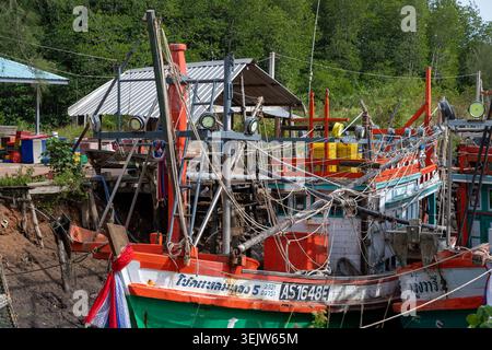 Krabi Thailand 19. Februar 2026. In Khlong Muang liegen farbenfrohe Fischerboote neben Arbeitsgeräten an der Küste. Stockfoto