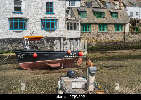 Polperro Harbour bei Niedrigwasser mit Boot auf der Hafenebene, Cornwall Stockfoto