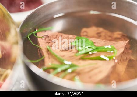 Yukhoe Bibimbap bietet frisches rohes Rindfleisch über Reis und Gemüse. Gepaart mit klarer Ochsenblutsuppe und Beilagen bietet es eine herzhafte koreanische Mahlzeit. Stockfoto