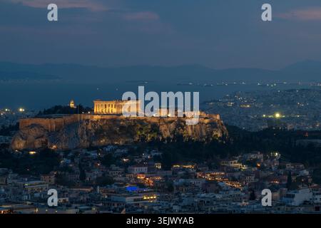 Das Parthenon, auf dem Akropolis-Hügel, mit Blick auf die antike Stadt Athen, beleuchtet, wenn der Abend über das mittelmeer fällt Stockfoto