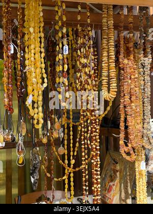 Bernsteinperlen in einem Straßenladen. Oranges Ostsee-Souvenir, Naturschmuck, Goldbraune Steinhalskette Stockfoto
