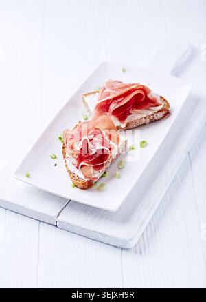 Leckere Sandwiches mit Frischkäse und geräuchertem Schinken Stockfoto
