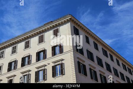 Klassisches europäisches Apartmentgebäude mit Fensterläden unter blauem Himmel in Rom, Italien Stockfoto