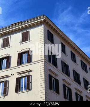 Elegantes weißes Wohngebäude mit traditionellen Fensterläden in Rom, Italien Stockfoto