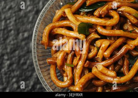 Gebratene Udon-Nudeln mit Gemüse auf Teller Nahaufnahme. Asiatische Küche und hausgemachtes Zubereitungskonzept. Stockfoto