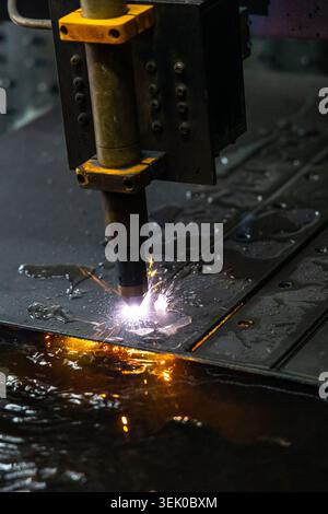 Plasmaschneidemaschine, die Metallbleche mit Funken im Werk verarbeitet Stockfoto
