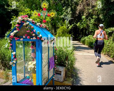 Ein kleiner, mit Blumen geschmückter Straßenschrein neben dem grünen Fußgängerweg auf der Avenida Amsterdam in Hipódromo Condesa, Mexiko-Stadt, spiegelt den alltäglichen Glauben und die populäre mexikanische Kultur wider Stockfoto