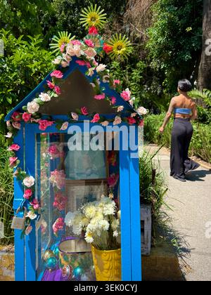 Ein kleiner, mit Blumen geschmückter Straßenschrein neben dem grünen Fußgängerweg auf der Avenida Amsterdam in Hipódromo Condesa, Mexiko-Stadt, spiegelt den alltäglichen Glauben und die populäre mexikanische Kultur wider Stockfoto