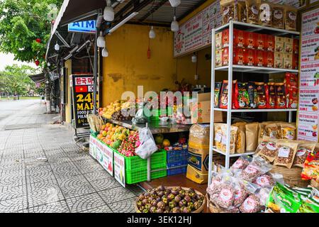 HOI AN, VIETNAM - 19. APRIL 2026: Örtlicher Lebensmittelladen und Obststand, der tropische Früchte und Kaffee auf einer Straße in Hoi an antiker Stadt verkauft Stockfoto