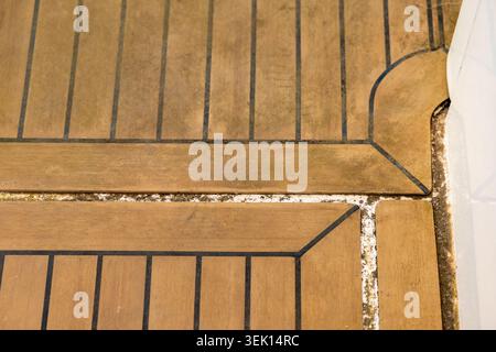 Detaillierte Ansicht der natürlichen Holzmaserung und Textur des Teakdeckels eines Bootes mit Anzeichen von Alter und Gebrauch Stockfoto