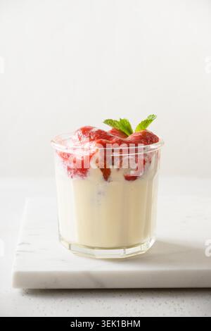 Layered Erdbeere Kleinigkeit Dessert Cookie Savoyardi, Mascarpone und Schlagsahne auf weißem Hintergrund. Vertikale Ausrichtung. Nahaufnahme. Stockfoto