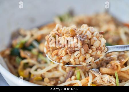 Koreanische Doenjang Bori Bibimbap-Sequenz. Dickflüssige Sojabohnenpaste gemischt mit plumpem Gerstenreis und frischem Gemüse für eine gesunde, rustikale lokale Mahlzeit. Stockfoto