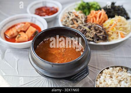 Koreanische Doenjang Bori Bibimbap-Sequenz. Dickflüssige Sojabohnenpaste gemischt mit plumpem Gerstenreis und frischem Gemüse für eine gesunde, rustikale lokale Mahlzeit. Stockfoto