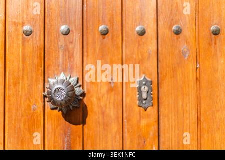 Dekorativer, antiker Türgriff und Schlüsselloch an traditioneller hölzerner Eingangstür, Nahaufnahme architektonischer Details Stockfoto
