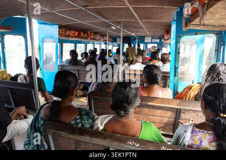 Passagiere, die in einer lokalen öffentlichen Fähre sitzen und durch die Backwaters in Alleppey (Alappuzha), Kerala, Indien navigieren. Stockfoto