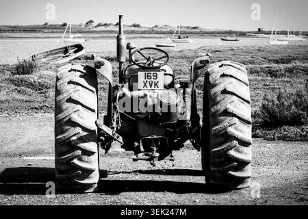 Ein alter Traktor, der von den Fischern in Brancaster Staithe in Norfolk benutzt wurde, wurde auf Mono-Film gedreht Stockfoto