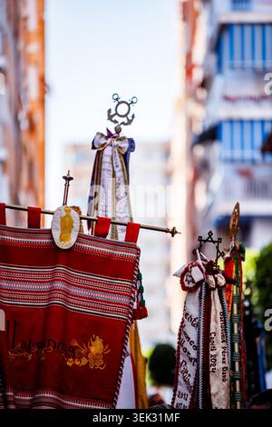 Eine Nahaufnahme des traditionellen rot gestickten Banners und der dekorativen Heraldik der Gruppe „Llauradors“ (Bauern) während einer Parade in den Straßen von Vil Stockfoto