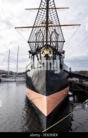 Vintage-Segelboot von vorne gesehen, Nahaufnahme seines schwarz-roten Rumpfes und Mast, in einem Hafen in den Niederlanden Stockfoto