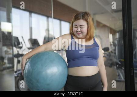 Sportliche Frau beim Balltraining, Fitnesstraining und Gesundheitskonzept. Training, Training und Sitzen auf Gymnastik, Fitball im Fitnessstudio Stockfoto