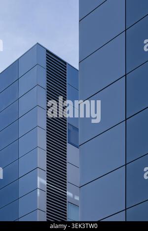 Moderne blaue Fassade des Firmengebäudes mit geometrischen architektonischen Linien Stockfoto