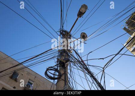 Reisefotografie. Telekommunikation, Faseroptik-Erweiterung. Glasfaserkabel über Straßenlaternen, Tirana, Albanien Stockfoto