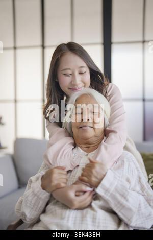 Porträt von Großmutter mit Enkelin, Familie, Freizeit, sitzend auf der Couch zu Hause Stockfoto