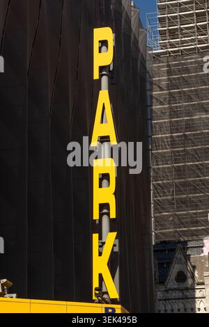 Gelbes Parkschild an einer modernen Gebäudefassade in Philadelphia, Pennsylvania, mit urbanen architektonischen Details. Stockfoto