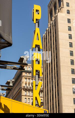 Gelbes Parkschild an einer modernen Gebäudefassade in Philadelphia, Pennsylvania, mit urbanen architektonischen Details. Stockfoto