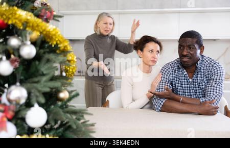 Eine ältere Frau schimpft ein verheiratetes Paar, während sie Weihnachten feiert Stockfoto
