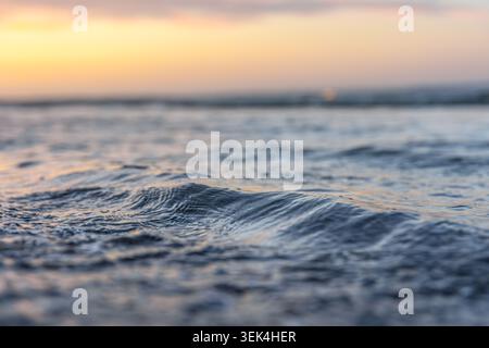 Niedriger Blick auf die Meereswellen am Abend. Natürlicher Wasserhintergrund mit sanfter Beleuchtung. Stockfoto