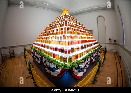 Renwick Gallery Home Canning Display Glas Einmachgläser Pyramide Washington DC Vereinigte Staaten | WASHINGTON D.C., Vereinigte Staaten – mehr als siebenhundert leuchtende einmachgläser mit selbst eingemachtem Essen steigen in einer gestuften Pyramide in der Renwick Gallery auf, gekrönt von einer mundgeblasenen Glasbirne. Die Installation wurde von Rod Zeitler, dem Konkurrenten der Iowa State Fair, erbaut und mit Glasarbeiten von Flora C. Mace und Joey Kirkpatrick gekrönt. Sie erinnert an Gartenbauvorstellungen aus dem frühen 20. Jahrhundert, die einst auf staatlichen Messen zur Förderung der landwirtschaftlichen Bildung und der Erhaltung von Häusern verwendet wurden. Stockfoto
