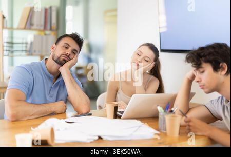 Müde Büroangestellte, die am Arbeitsplatz ein Nickerchen machen Stockfoto