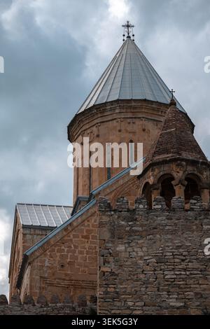 Flacher Blick auf eine alte Steinkuppel der Kathedrale und eine befestigte Mauer unter dramatischen Wolken Stockfoto