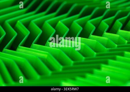 Makroansicht hellgrüner, strukturierter Chevron-Linien, die einen futuristischen abstrakten Hintergrund schaffen Stockfoto