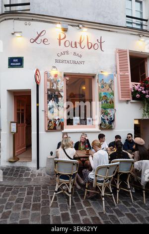 Gäste sitzen vor dem Café-Bar-Restaurant Le Poulbot in der Rue Poulbot in Montmartre, Paris. Stockfoto