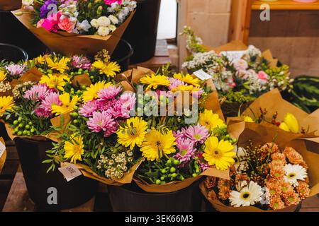 Bunte Blumensträuße in Eimern auf einem Markt Stockfoto