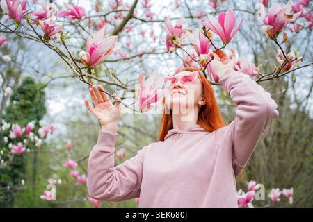Ginger Frau in herzförmiger Sonnenbrille genießt Frühling und Stockfoto