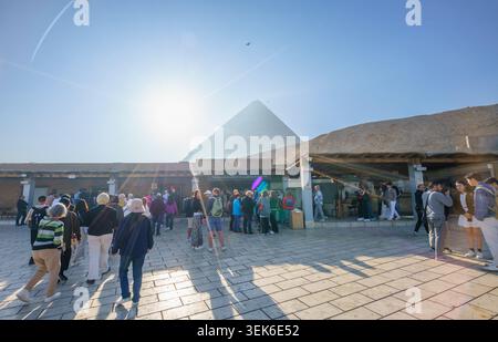 Gizeh, Ägypten - 21. Januar 2025: Touristen versammeln sich an einem sonnigen Morgen im Eintrittskartenbereich des Pyramidenkomplexes von Gizeh, mit der Großen Pyramide VI Stockfoto