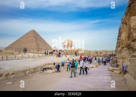 GIZEH, ÄGYPTEN - 21. JANUAR 2025: Touristen spazieren auf dem Sandweg in der Nähe der Großen Sphinx und der Großen Pyramide von Gizeh und erkunden die historische Antike Stockfoto
