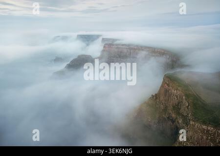 Blick aus der Vogelperspektive auf den Giants Causeway, umgeben von dickem Morgennebel und Nebel über den zerklüfteten Basaltklippen Bushmills, Nordirland, Großbritannien. Stockfoto