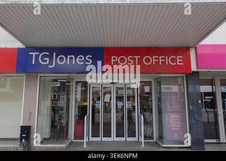 TG Jones und Post Office Storefront. Automatische Haupteingangstüren aus Glas, flankiert von großen Glasfenstern unter einem breiten, modernen überdachten Vordach. Stockfoto
