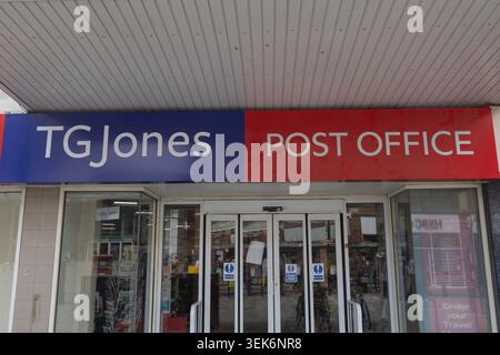 TG Jones und Post Office Storefront. Automatische Haupteingangstüren aus Glas, flankiert von großen Glasfenstern unter einem breiten, modernen überdachten Vordach. Stockfoto
