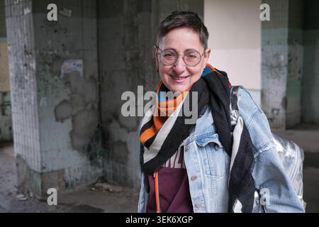 Eine Person steht selbstbewusst in einem leeren Gebäude und zeigt Freude und Stil. Stockfoto