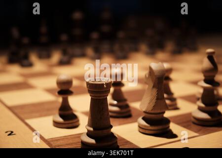 Hölzerne Schachfiguren, die während des strategischen Spiels auf dem Schachbrett angeordnet wurden Stockfoto