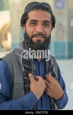 Afghane lächelt für ein Nahporträt, trägt eine Totenkopfkappe in der Nähe der blauen Moschee. Stockfoto