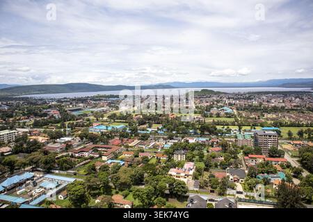 Aus der Vogelperspektive auf die urbane Landschaft der Stadt Nakuru mit Wohngebäuden und Grünflächen mit dem See Nakuru und entfernten Hügeln im Hintergrund Stockfoto
