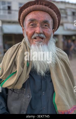 Lächelnder älterer Mann mit Pakolmütze im hindukusch Stockfoto