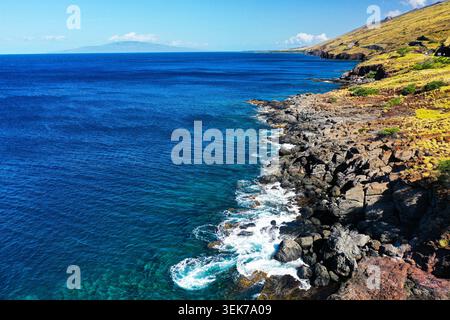 Ein Blick aus der Vogelperspektive auf die atemberaubende felsige Küste von Maui, Hawaii, mit lebhaftem türkisfarbenem Wasser, zerklüfteten Klippen und üppigem Grün im Kontrast zu Stockfoto